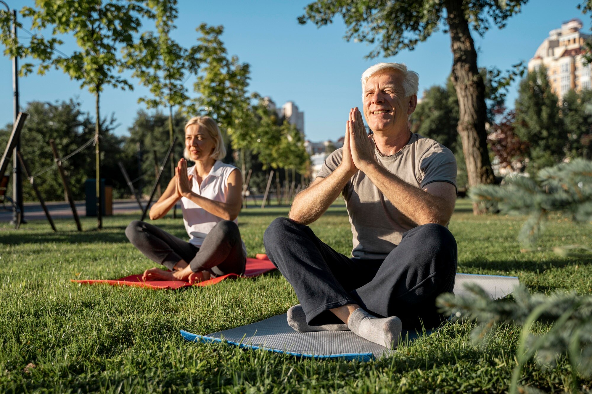 Grupo de personas adultas practicando yoga y estiramientos en el parque bajo el sol de la mañana en México